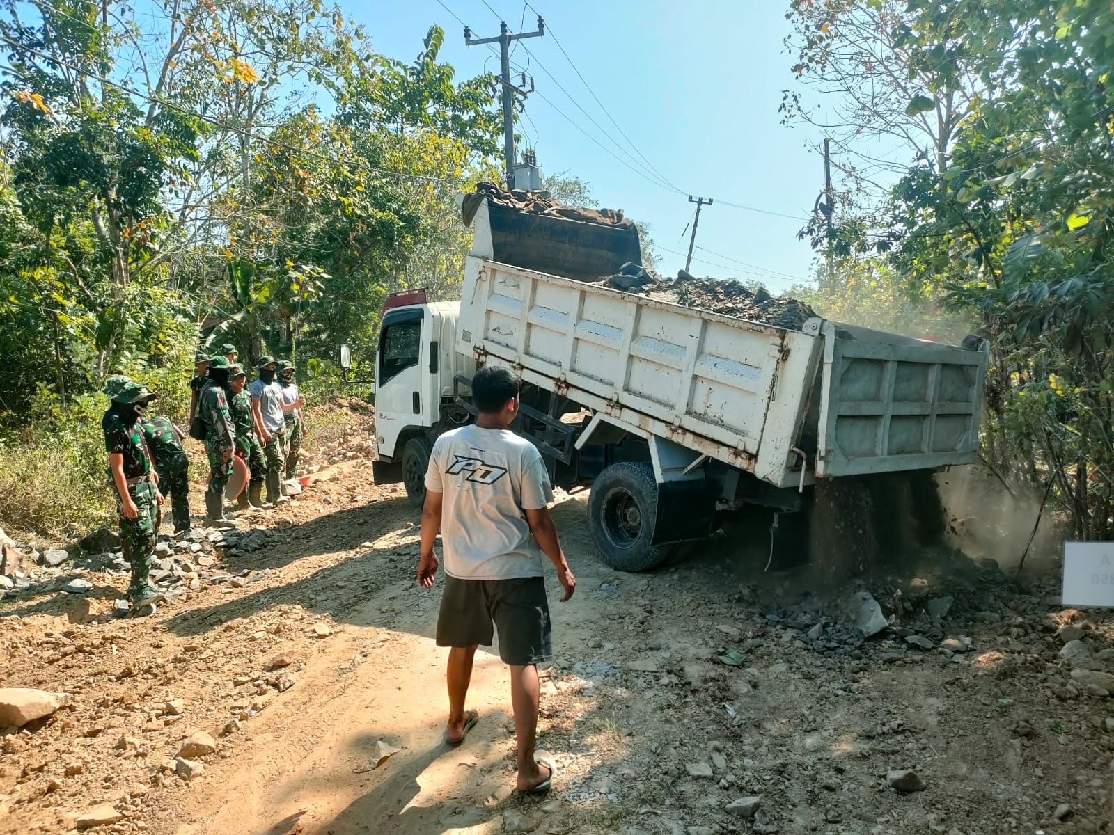 Angkutan Dump Truk Tengah Menurunkan Matrial Batu dalam Kegiatan TMMD Ke 129 Membuka Akses Jalan Penghubung Antara Desa Pasirgadung dengan Desa Simpang Tiga Kecamatan Patia.